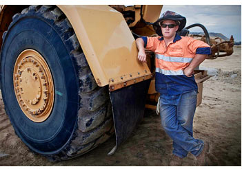 mining scene miner standing next to scraper machine